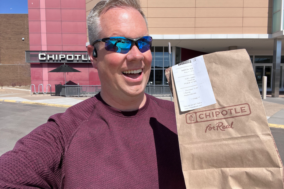 Aaron Hurd holding a Chipotle bag in front of a Chipotle.