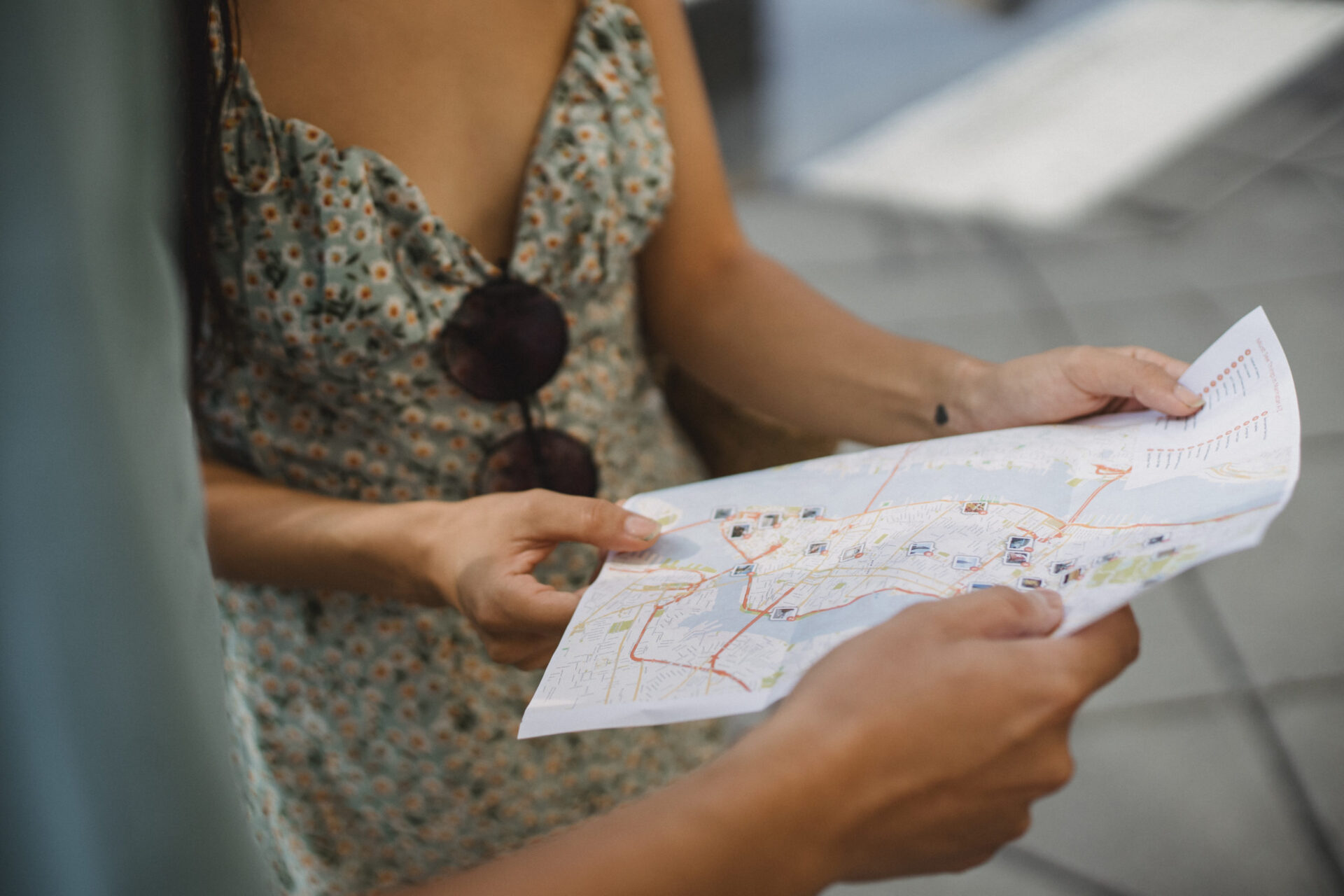 Crop faceless couple checking direction on city map