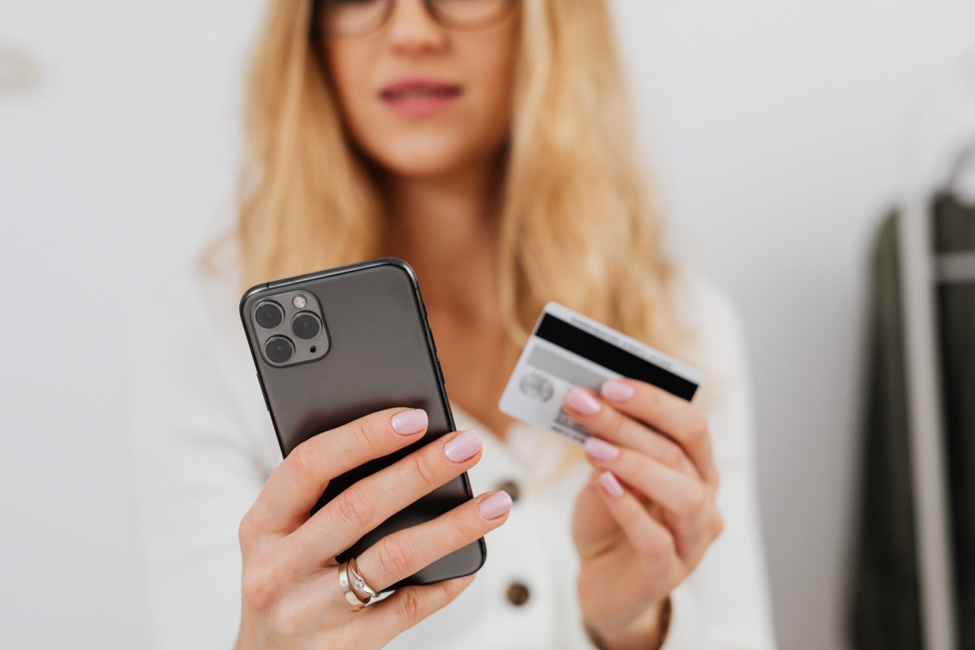 Close up shot of a woman holding a credit card and smartphone