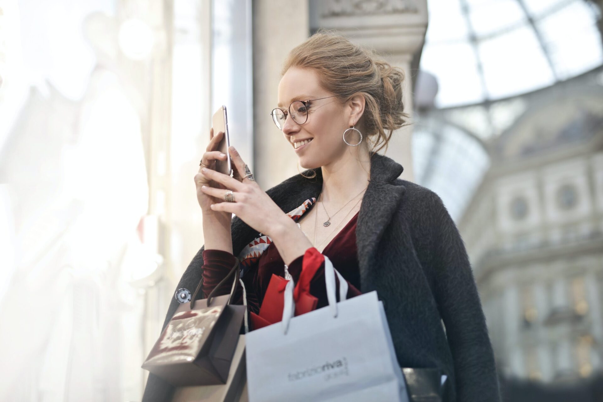 Woman standing near wall holding phone