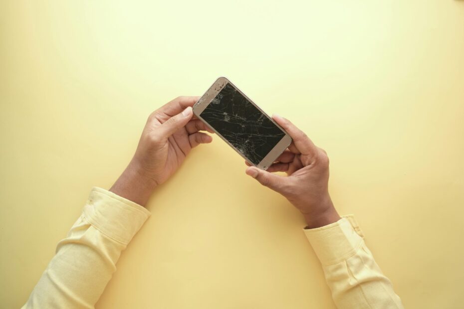 Close up shot of a person holding a broken smartphone